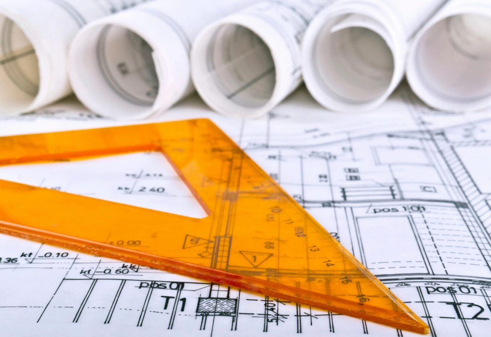 Orange set square on architectural blueprints